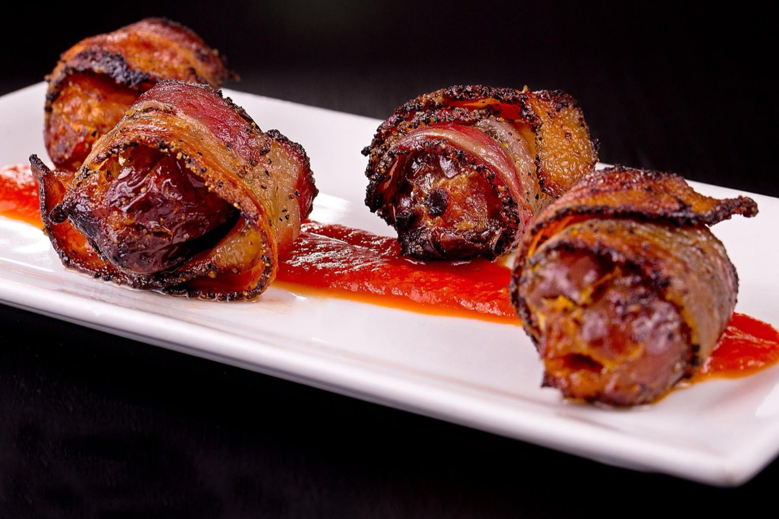 Bacon-wrapped scallops on a white plate